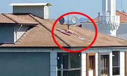 Çatıda çıplak halde güneşlendi, polis sirenini duyunca kaçtı