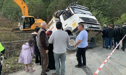 Kontrolden çıkan kamyon, altına aldığı otomobille dereye düştü