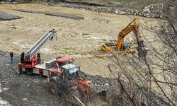 Çayın debisi yükselince iş makinesinin üzerinde mahsur kaldı