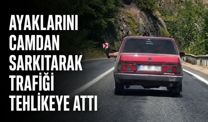 Ayaklarını camdan sarkıtarak trafiği tehlikeye attı