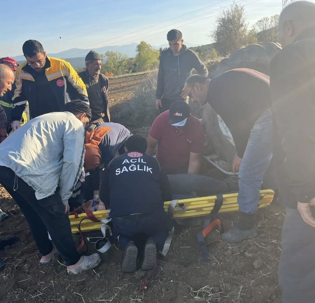 Devrilen traktörün altında kalan sürücü yaralandı
